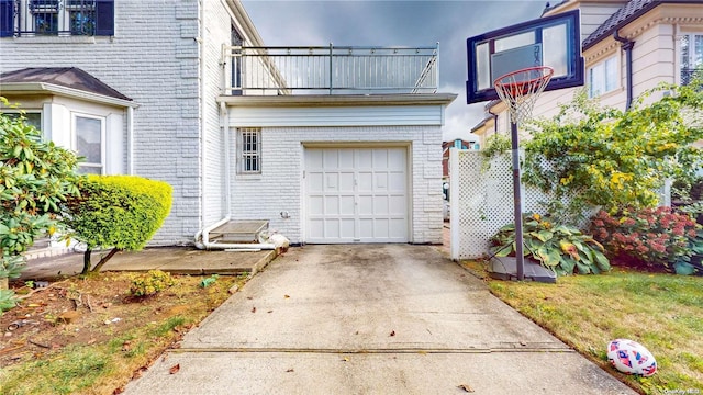 exterior space with brick siding, concrete driveway, and a balcony