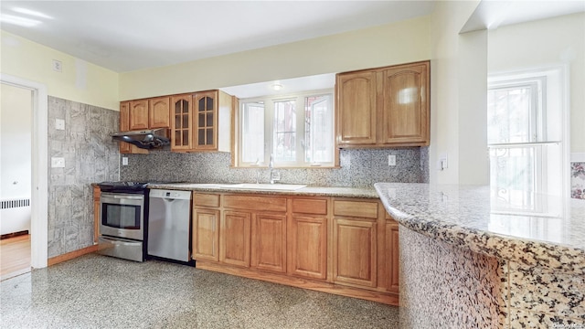 kitchen featuring tasteful backsplash, radiator heating unit, dishwasher, and sink