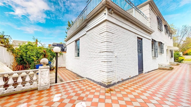 view of side of home featuring a balcony and a patio area