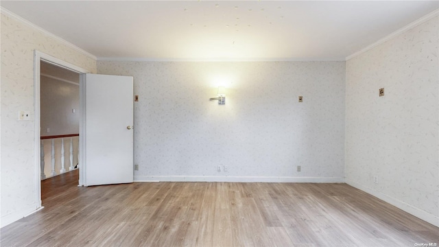 empty room with crown molding and light hardwood / wood-style flooring