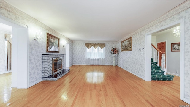 unfurnished living room featuring a brick fireplace and wood-type flooring