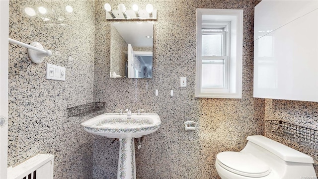 bathroom featuring toilet and backsplash