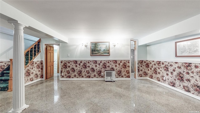 finished basement with wallpapered walls, stairway, baseboards, and a wainscoted wall