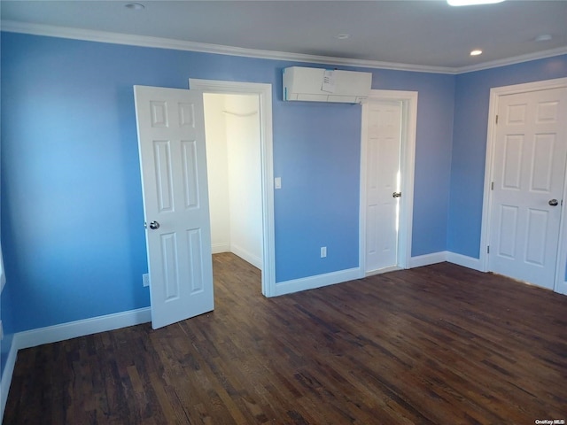 unfurnished bedroom with a wall mounted air conditioner, crown molding, and dark wood-type flooring