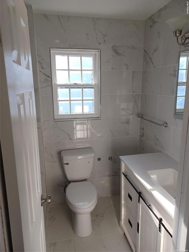 bathroom featuring vanity, tile walls, and toilet