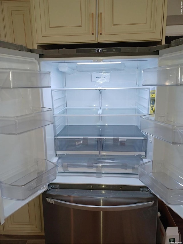 interior details featuring cream cabinetry and stainless steel fridge