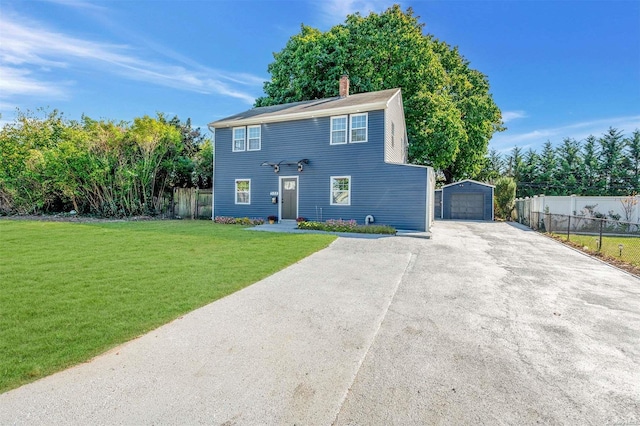 view of front facade featuring a front yard, an outbuilding, and a garage