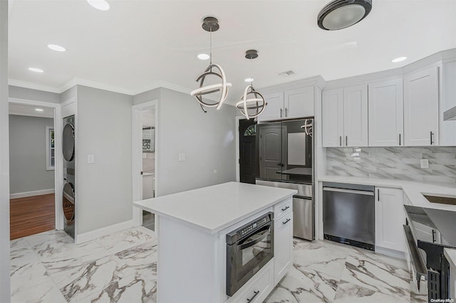 kitchen with stacked washer and clothes dryer, white cabinets, crown molding, decorative backsplash, and black oven