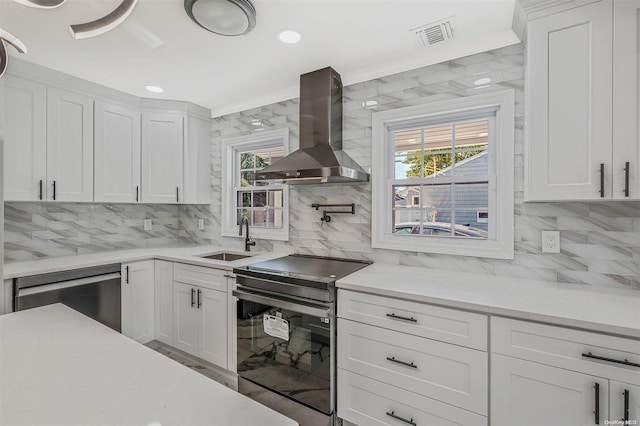 kitchen with white cabinetry, wall chimney exhaust hood, and stainless steel range with electric cooktop