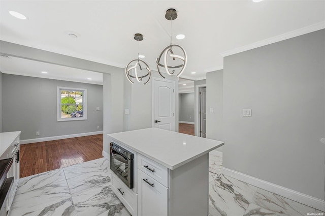 kitchen featuring light wood-type flooring, ornamental molding, an inviting chandelier, white cabinets, and hanging light fixtures