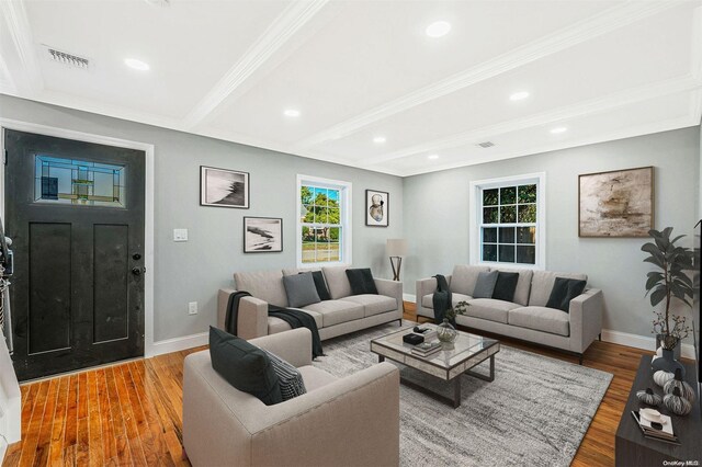 living room featuring beamed ceiling, wood-type flooring, and crown molding