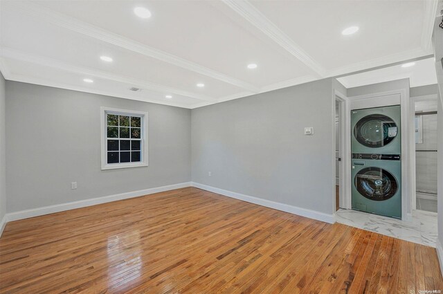 interior space with crown molding, light hardwood / wood-style floors, and stacked washer and clothes dryer