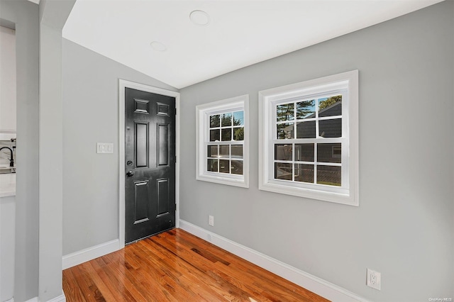 entrance foyer featuring hardwood / wood-style floors, lofted ceiling, and sink