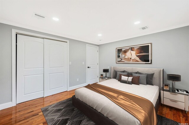 bedroom featuring crown molding, a closet, and hardwood / wood-style flooring