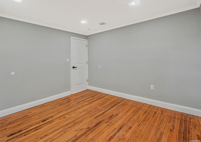 unfurnished room with hardwood / wood-style floors and ornamental molding