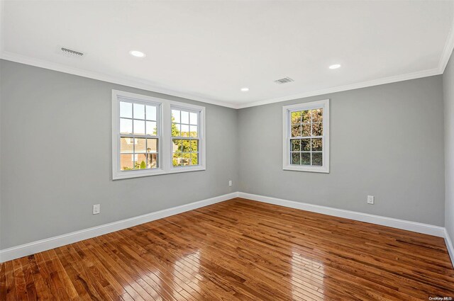 empty room with wood-type flooring and crown molding