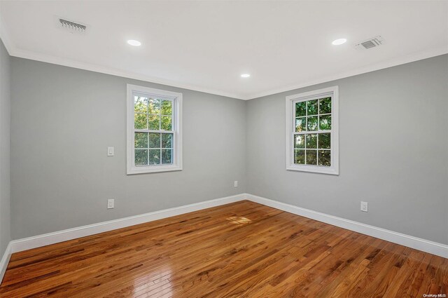 unfurnished room featuring hardwood / wood-style floors and ornamental molding