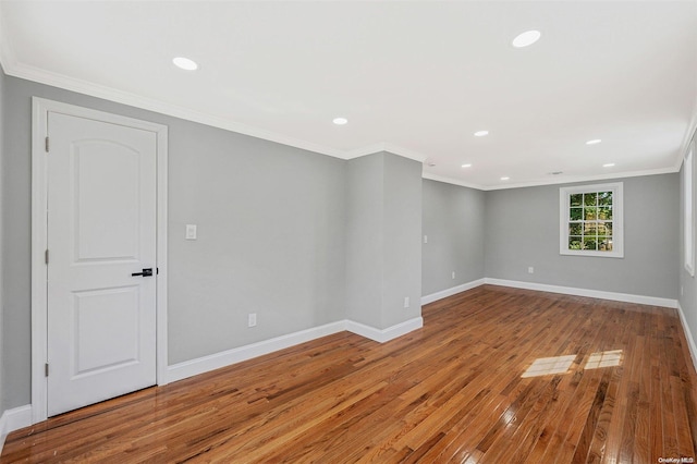 empty room with crown molding and light hardwood / wood-style flooring