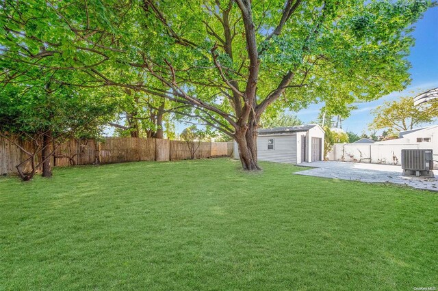 view of yard with a patio, central AC, and an outdoor structure