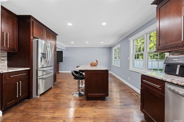 kitchen featuring decorative backsplash, stainless steel appliances, light stone counters, and dark hardwood / wood-style floors