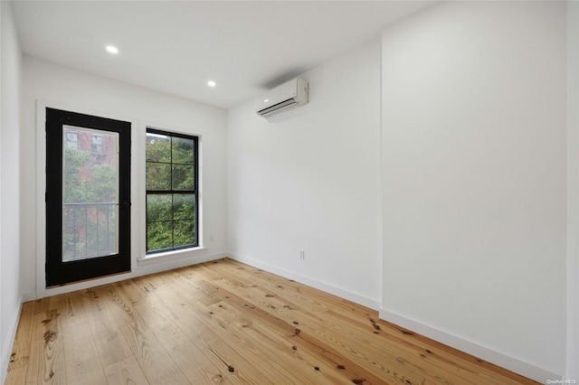 unfurnished room featuring wood-type flooring and an AC wall unit