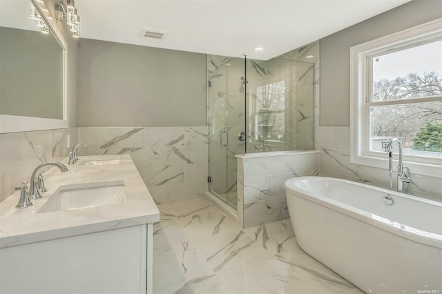 bathroom featuring shower with separate bathtub, vanity, and tile walls