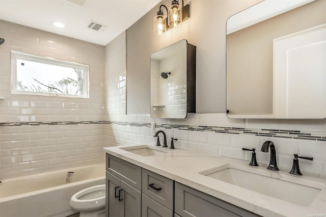 full bathroom with vanity, tasteful backsplash, toilet, and tiled shower / bath