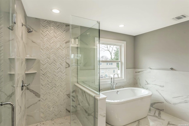 bathroom featuring tile walls and plus walk in shower