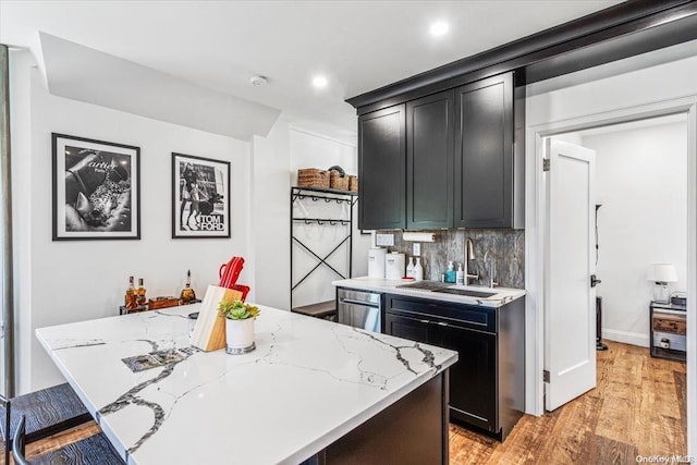 1 Station Sq Unit 315, Forest Hills, NY 11375 - kitchen featuring a sink, light wood-style floors, tasteful backsplash, stainless steel dishwasher, and a kitchen island