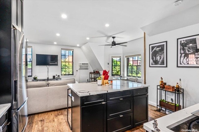 1 Station Sq Unit 315, Forest Hills, NY 11375 - kitchen with stainless steel refrigerator with ice dispenser, dark cabinets, open floor plan, light wood-style floors, and ceiling fan