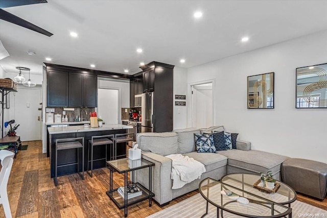 living room featuring sink and dark wood-type flooring