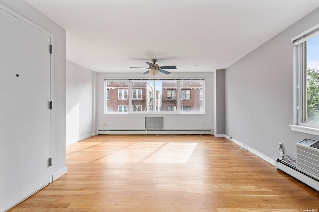 interior space with baseboard heating, plenty of natural light, and light wood-type flooring