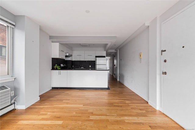 kitchen featuring white refrigerator, white cabinetry, backsplash, and light hardwood / wood-style flooring