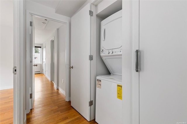 washroom featuring light hardwood / wood-style floors and stacked washer and dryer