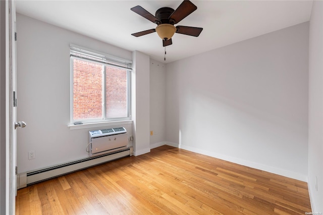 spare room featuring a wall mounted air conditioner, ceiling fan, baseboard heating, and light hardwood / wood-style flooring