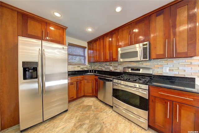 kitchen with decorative backsplash, sink, stainless steel appliances, and dark stone counters