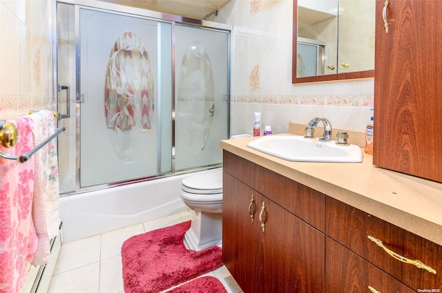 full bathroom with shower / bath combination with glass door, tile patterned floors, vanity, and tile walls