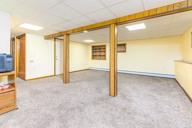 basement featuring a paneled ceiling and carpet floors