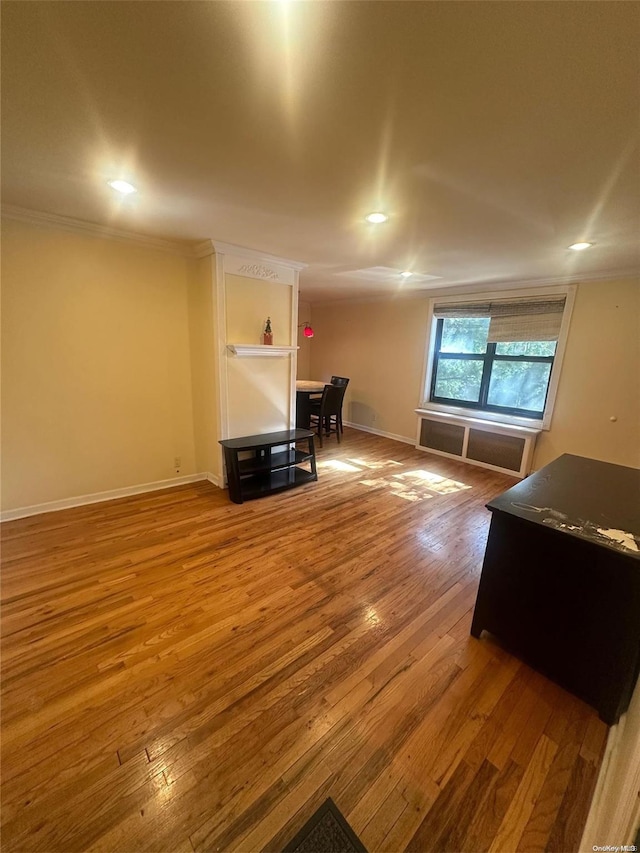 living room featuring wood-type flooring and crown molding