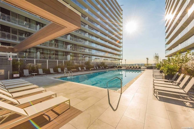 pool at dusk featuring a patio area