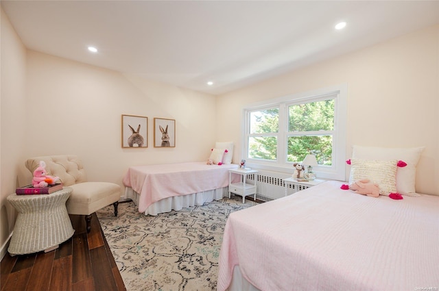 bedroom with radiator and hardwood / wood-style flooring