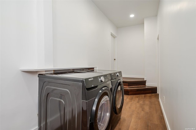 clothes washing area with independent washer and dryer and wood-type flooring