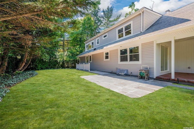 rear view of house with a lawn and a patio