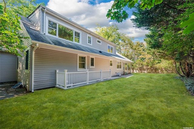 rear view of property featuring a lawn