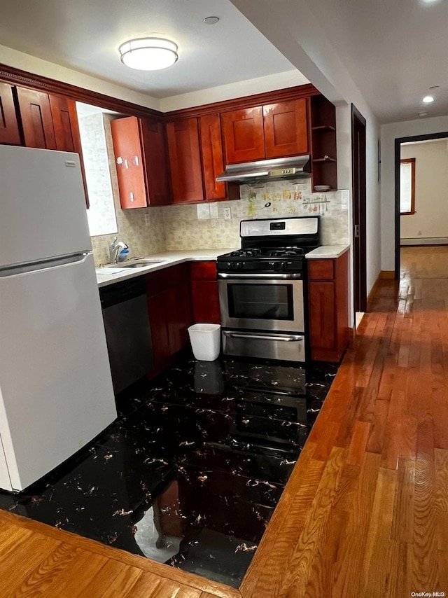 kitchen featuring sink, dark wood-type flooring, appliances with stainless steel finishes, and tasteful backsplash