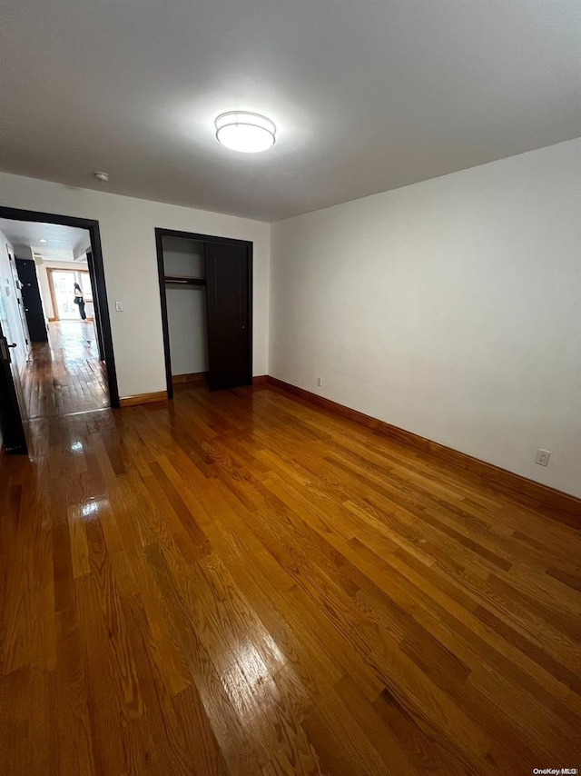 unfurnished bedroom with hardwood / wood-style flooring and a closet