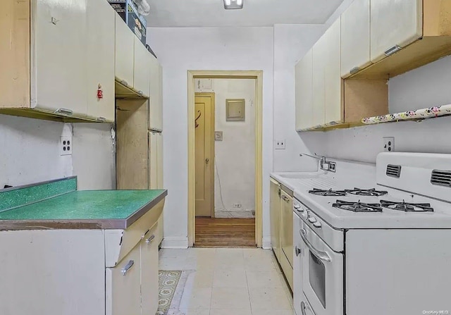 kitchen featuring white cabinetry, sink, white gas range oven, stainless steel dishwasher, and light wood-type flooring