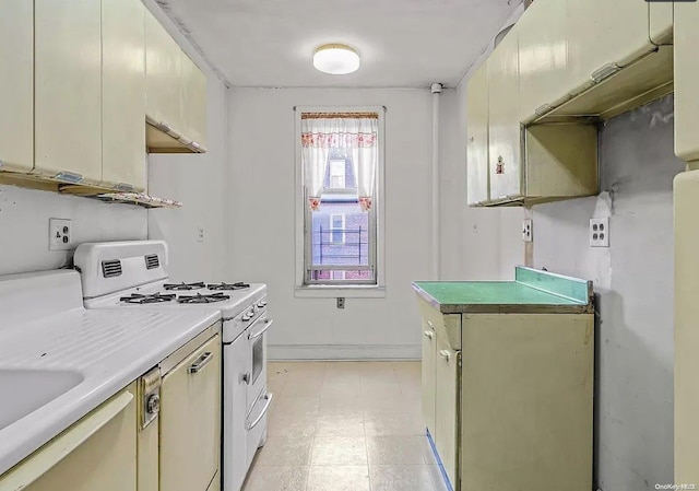 kitchen featuring cream cabinetry, white range, and sink