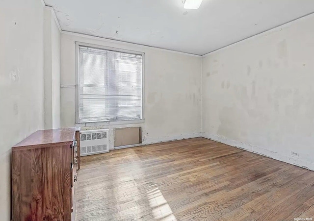 unfurnished room featuring radiator heating unit and light hardwood / wood-style flooring