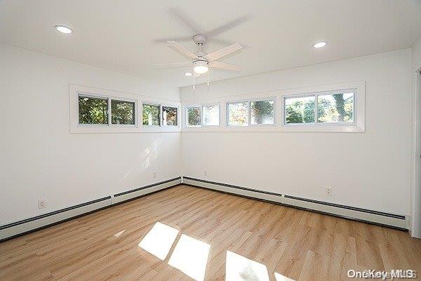 empty room featuring ceiling fan and light hardwood / wood-style flooring